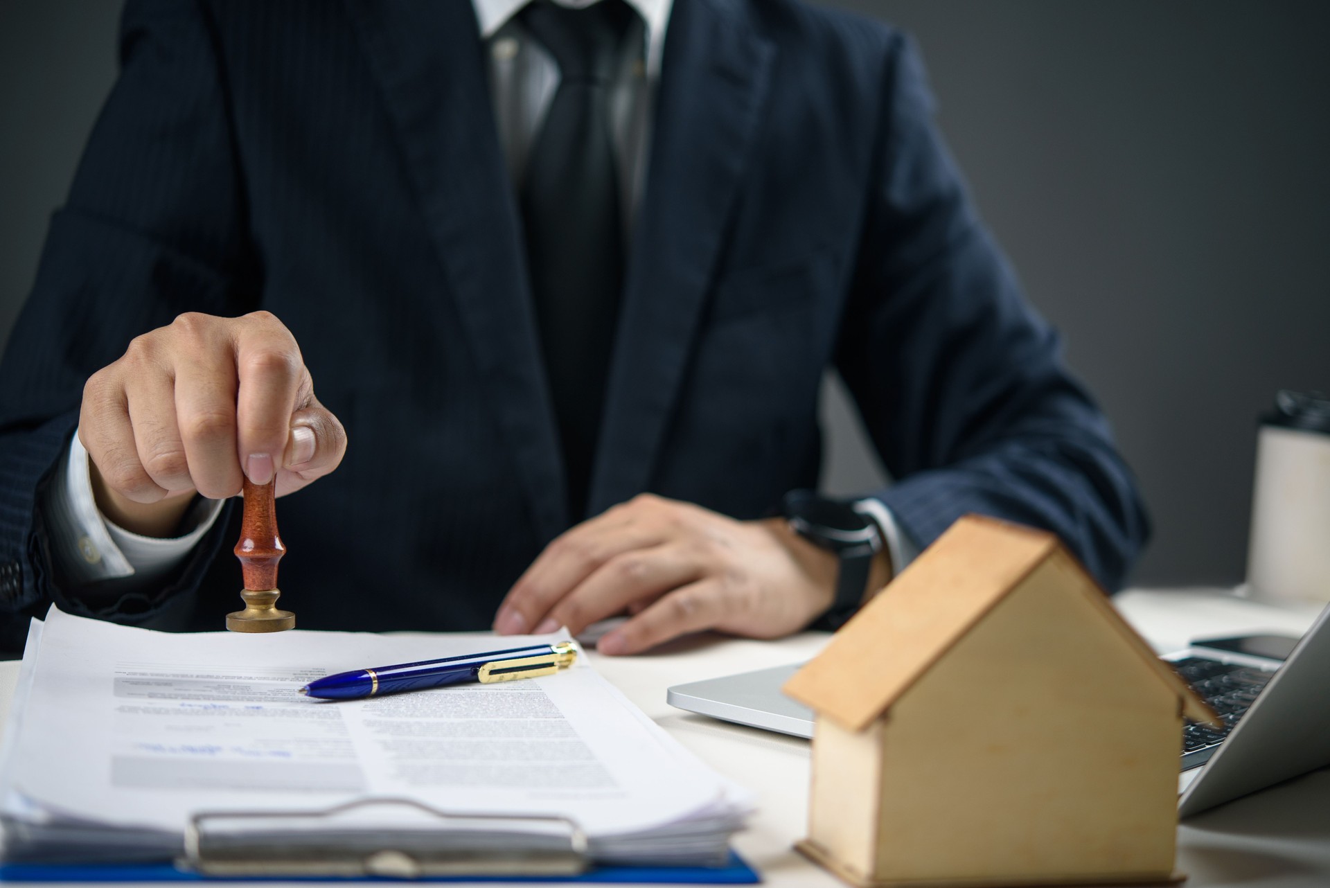 Businessman stamping approved on real estate contract. Concept of property agreement, mortgage approval, and legal documentation for home buying. Businessman stamping approved on real estate contract. Concept of property agreement, mortgage approval, and legal documentation for home buying.