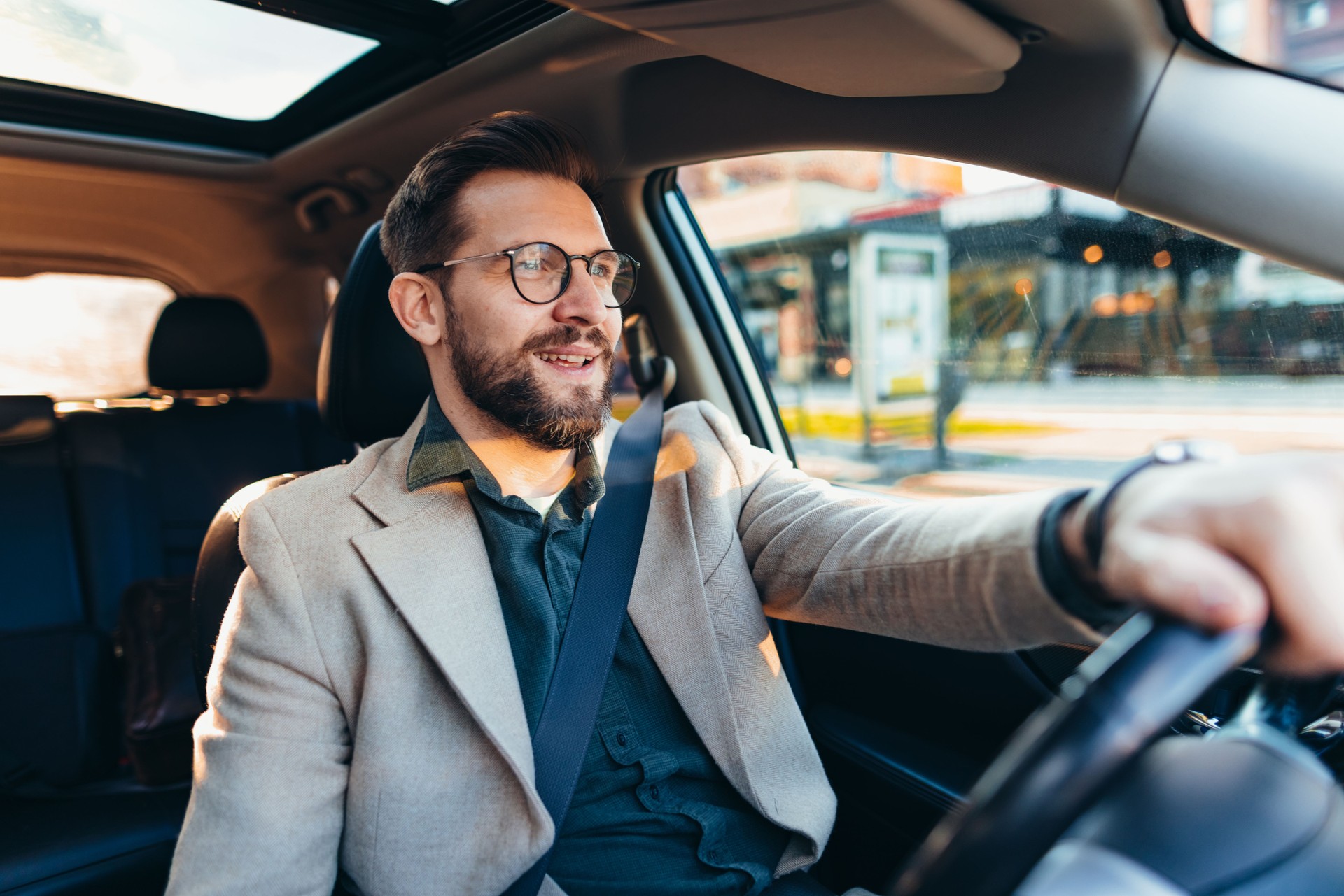 Businessman driving car in city during sunny day Businessman driving car in city during sunny day